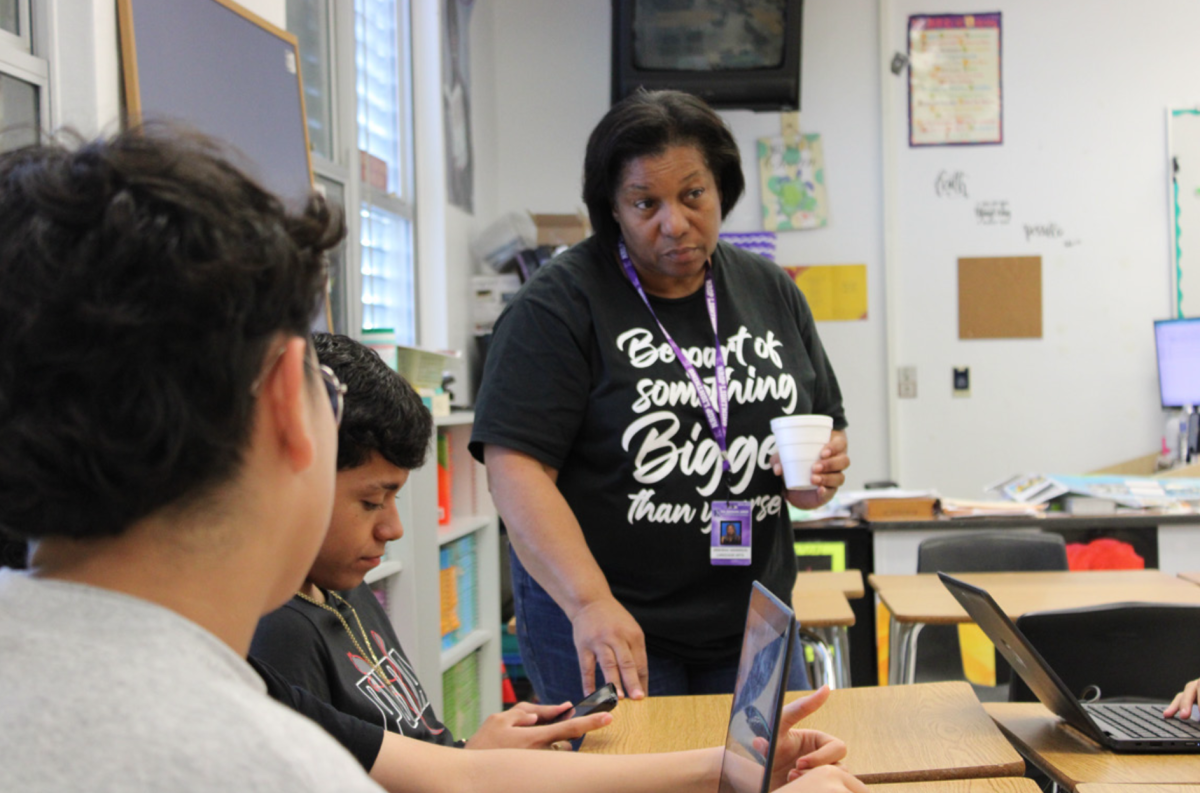 EDUCATING: English teacher Deborah Anderson assists a group of students with their Commonlit assignment in her 4th period English 1 through ESOL class. 